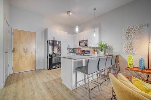 A modern kitchen with a bar area and a dining table.