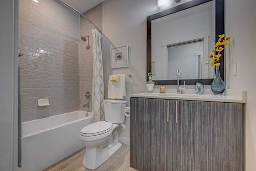A white toilet sits next to a bathtub in a bathroom.