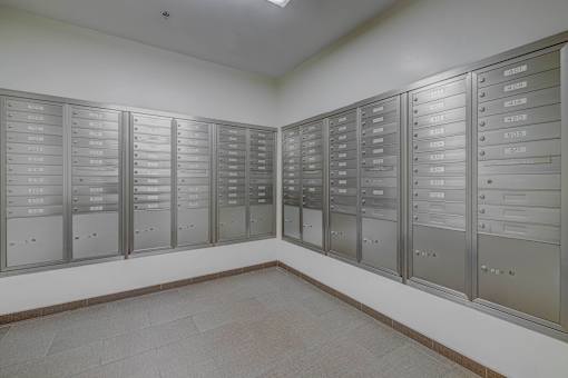 A room with a row of mailboxes on the wall.