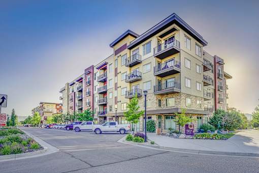 Apartment building with cars parked in front.