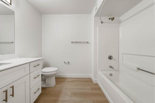 A white bathroom with a toilet, sink, and bathtub.