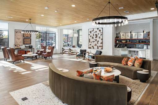A modern living room with a curved sofa and a chandelier.