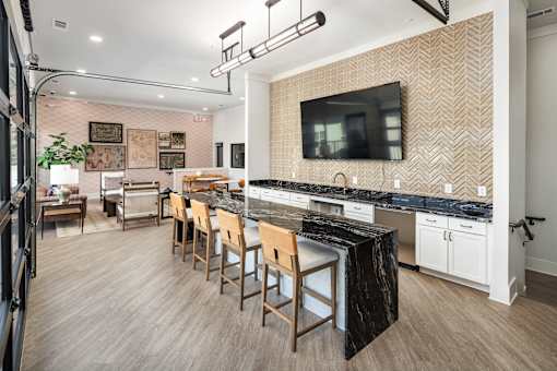 A kitchen with a bar area and a television mounted on the wall.