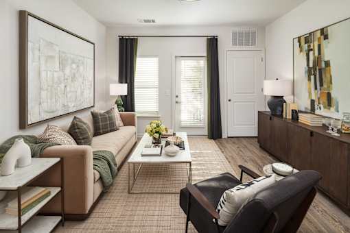 A living room with a couch, chair, and a painting on the wall.