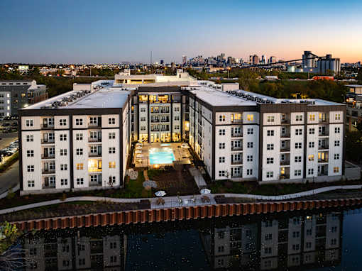 A modern apartment building with a pool in the middle of it.