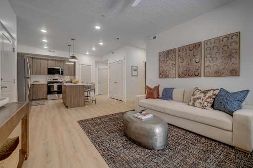 A living room with a couch, a coffee table, and a painting on the wall.