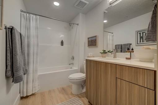 A modern bathroom with a toilet, sink, and shower.