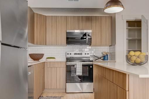 A modern kitchen with wooden cabinets and stainless steel appliances.