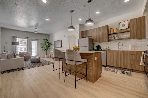 A modern kitchen with wooden cabinets and a bar area.