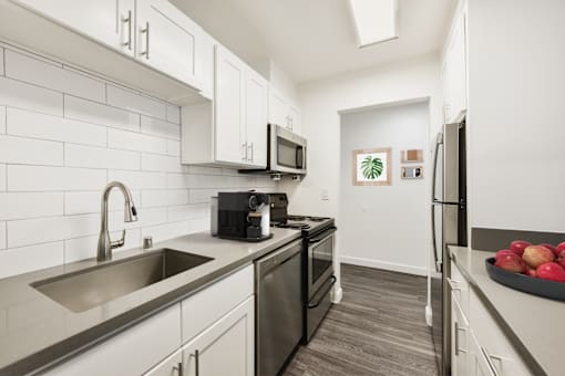 A kitchen with a black fridge and a black stove.
