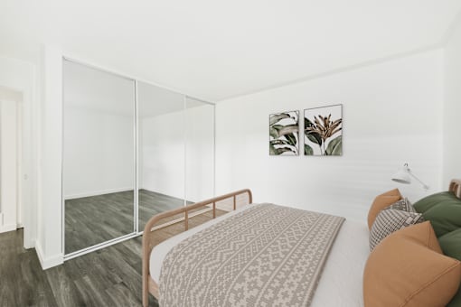A bedroom with a bed, a chair, and a painting on the wall.