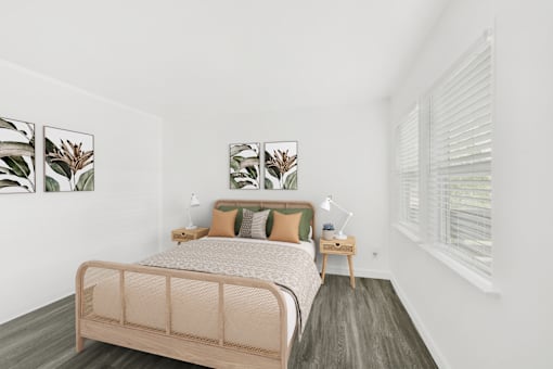 A bedroom with a bed, nightstands, and pictures on the wall.