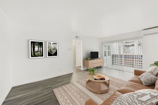 A living room with a brown couch, a coffee table, and two framed pictures on the wall.