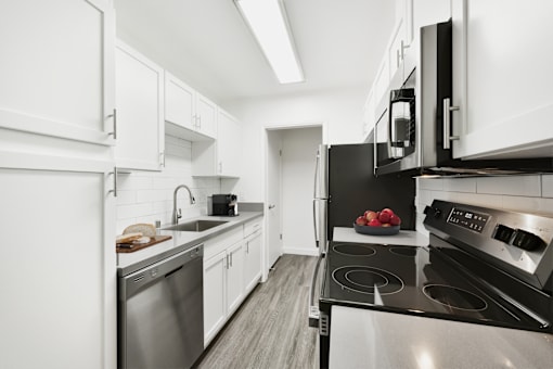 A modern kitchen with black and white appliances and cabinets.