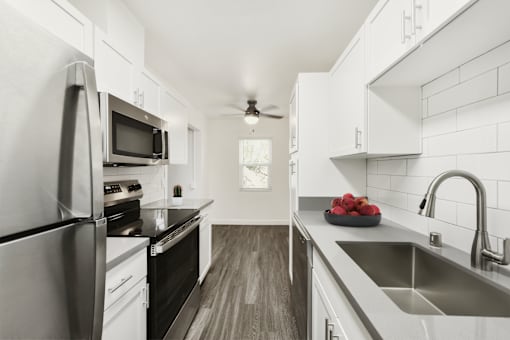 A modern kitchen with stainless steel appliances and white cabinets.