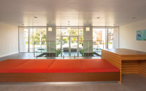 a large orange bench in a room with glass doors