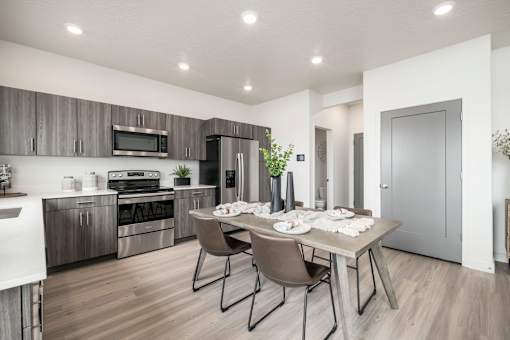A modern kitchen with a dining table set for two.