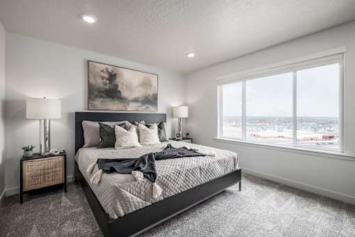 A bedroom with a large bed and a painting on the wall.
