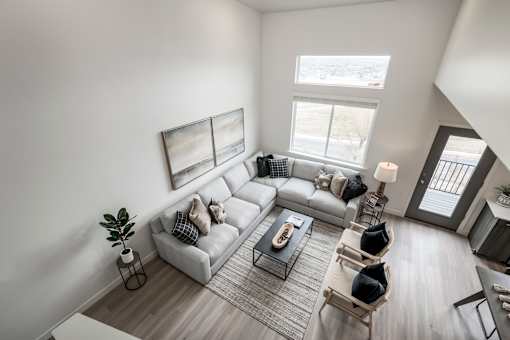 A living room with a grey couch, a coffee table, and a painting on the wall.