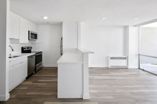 a kitchen with white cabinetry and a wooden floor