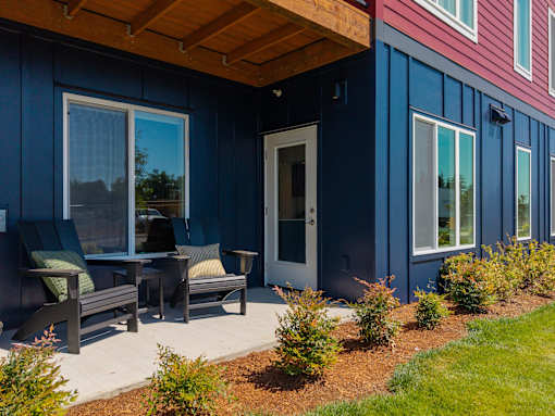 A blue house with a wooden porch and a white door.