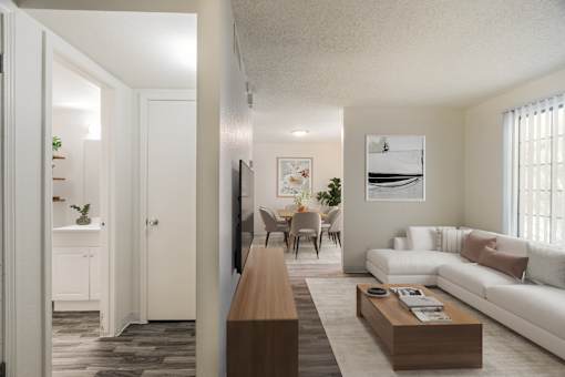 A living room with a white couch and a wooden coffee table.
