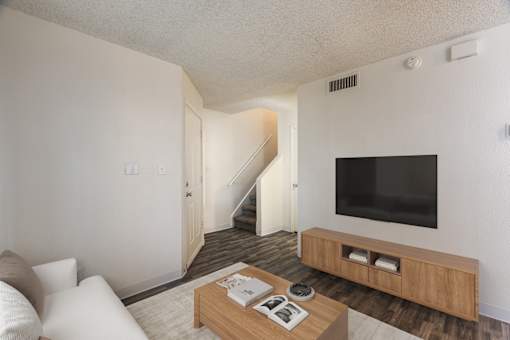 A living room with a staircase leading to the second floor.