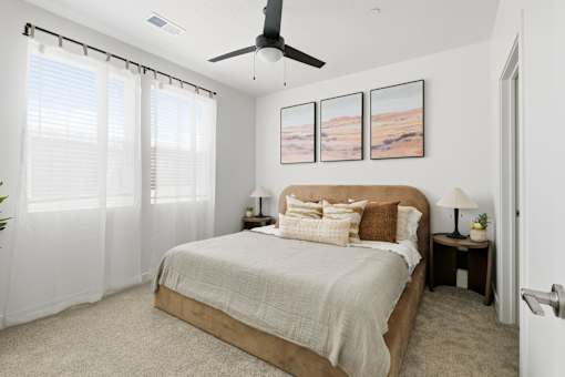 A bedroom with a large bed and a ceiling fan.