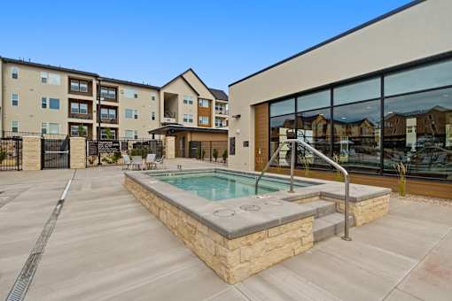 A swimming pool in a courtyard surrounded by apartment buildings.