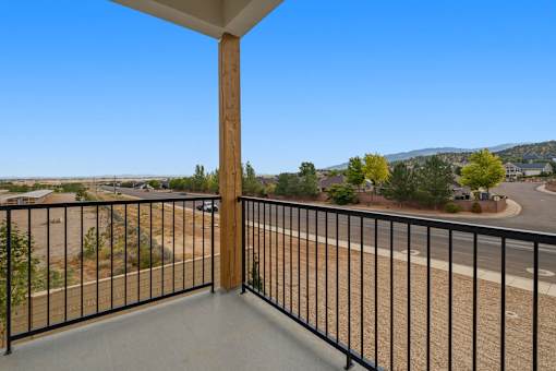 A balcony with a black railing and a wooden post.