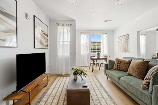 A living room with a green couch and a wooden coffee table.