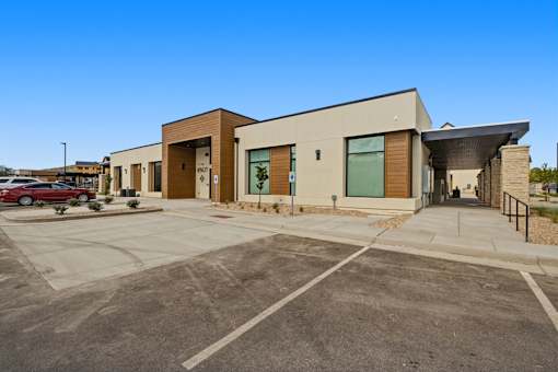 A modern building with a parking lot in front.