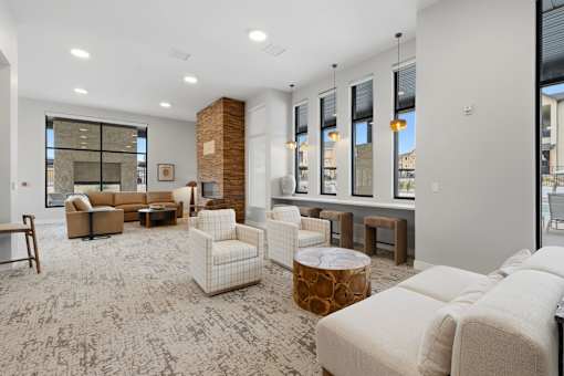 A living room with a carpeted floor and a brick pillar.