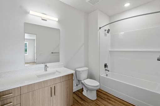 A white bathroom with a sink, toilet, and bathtub.