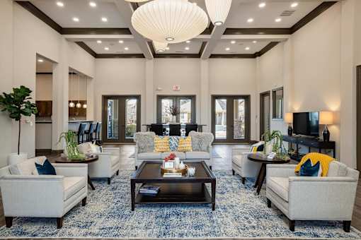 A well-lit, spacious living room with a variety of seating options and a coffee table.
