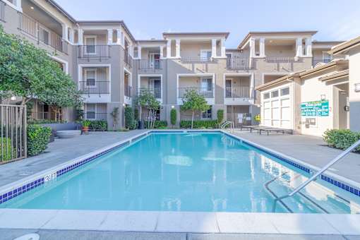 A swimming pool in front of apartment buildings.