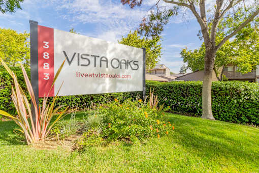A sign for Vista Oaks with a website listed on it.