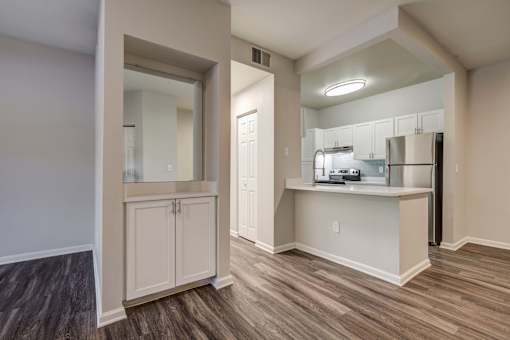 A kitchen area with a bar and a fridge.