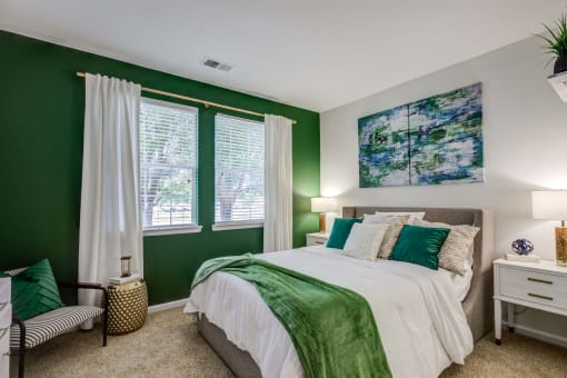 a bedroom with green walls and a bed with a large window