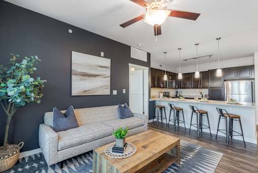 A living room with a grey couch and a wooden coffee table.