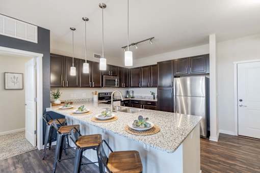 A kitchen with a large island and bar stools.