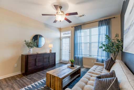 A living room with a brown wooden coffee table and a beige sofa.