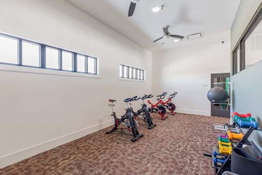 A room with exercise equipment and a ceiling fan.