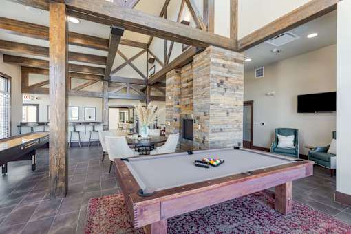 A pool table in a room with wooden beams on the ceiling.