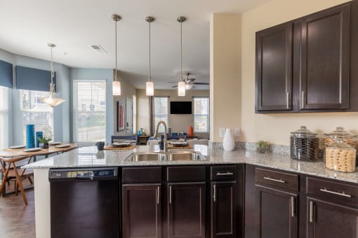 a kitchen with dark cabinets and a counter top with a sink