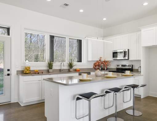 A modern kitchen with white cabinets and a central island.at The Yarra, Tennessee
