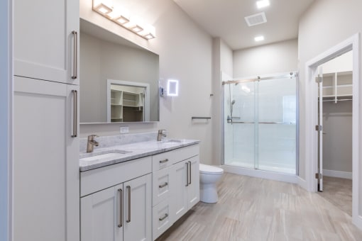 a bathroom with a toilet sink and a shower with a glass door