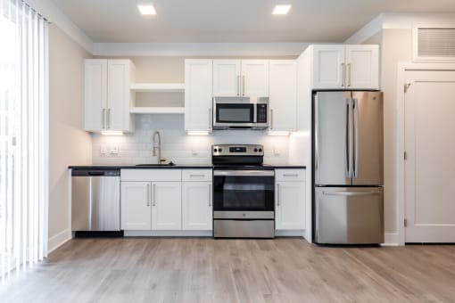 a kitchen with white cabinets and stainless steel appliances