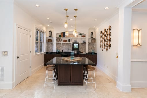 a kitchen with white walls and tiles flooring and a large center island with a black counter at Westmount at Ashwood, Georgia