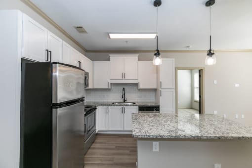 a kitchen with white cabinets and a granite counter top at Westmount at Ashwood, Atlanta